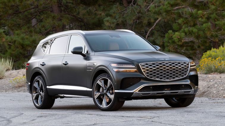 2025 Genesis GV80 3.5T in Storr Green with trees in the background.