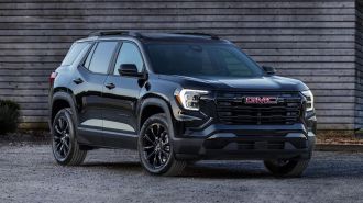 2025 GMC Terrain Elevation in black parked next to a barn.