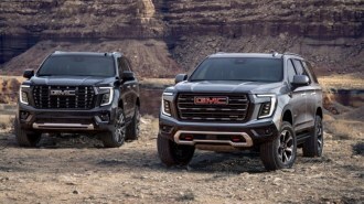 The 2025 GMC Yukon in Denali Ultimate and AT4 Ultimate trims, seen from a front quarter angle