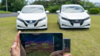 A photo showing two Nissan Leaf EVs, one cooler than the other in summer sun thanks to an experimental paint