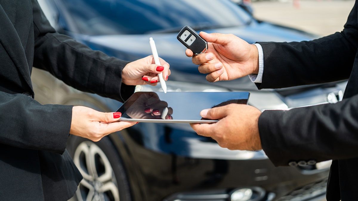 Young asian businesswoman buying new car with sale manager signing signature deal on tablet getting key and go to driving car. Buy sell rent concept. Hand sending key vehicle contract car deal