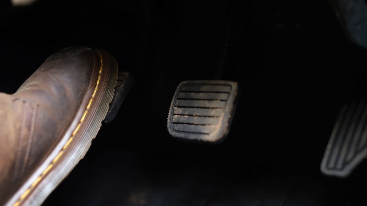 Foot, accelerator and brake pedal inside the car.