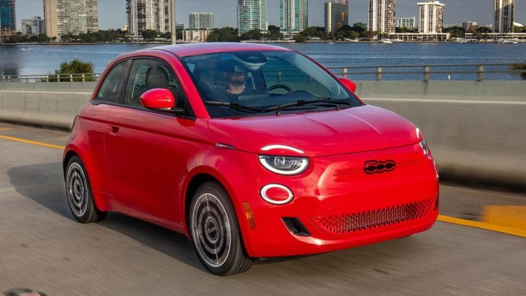 A red 2024 Fiat 500e driving in Miami, FL.