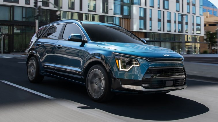 2025 Kia Niro PHEV in blue, driving through a city.