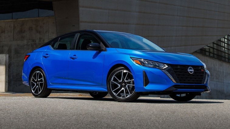 The 2025 Niussan Sentra in blue, parked in front of a building.
