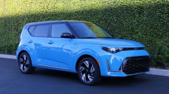 2025 Kia Soul GT Line in blue next to an ivy wall.