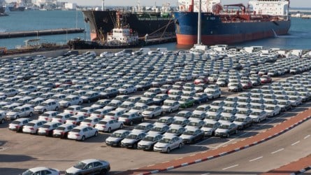 Cars parked in a port near roll-on/roll-off container ships