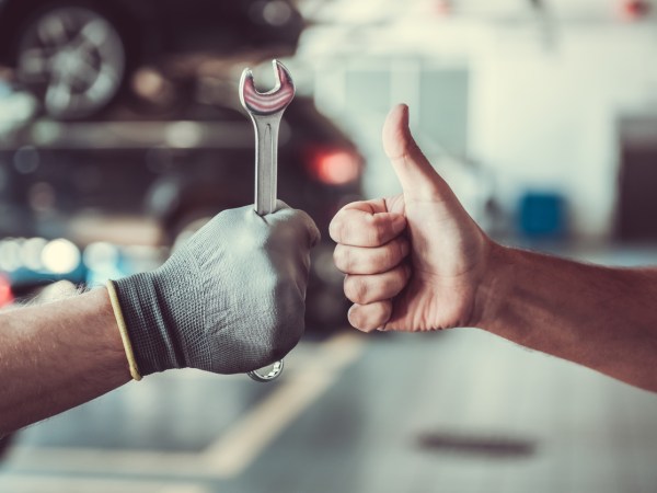 Premium Photo  Male hand holding car auto icon on blue surface